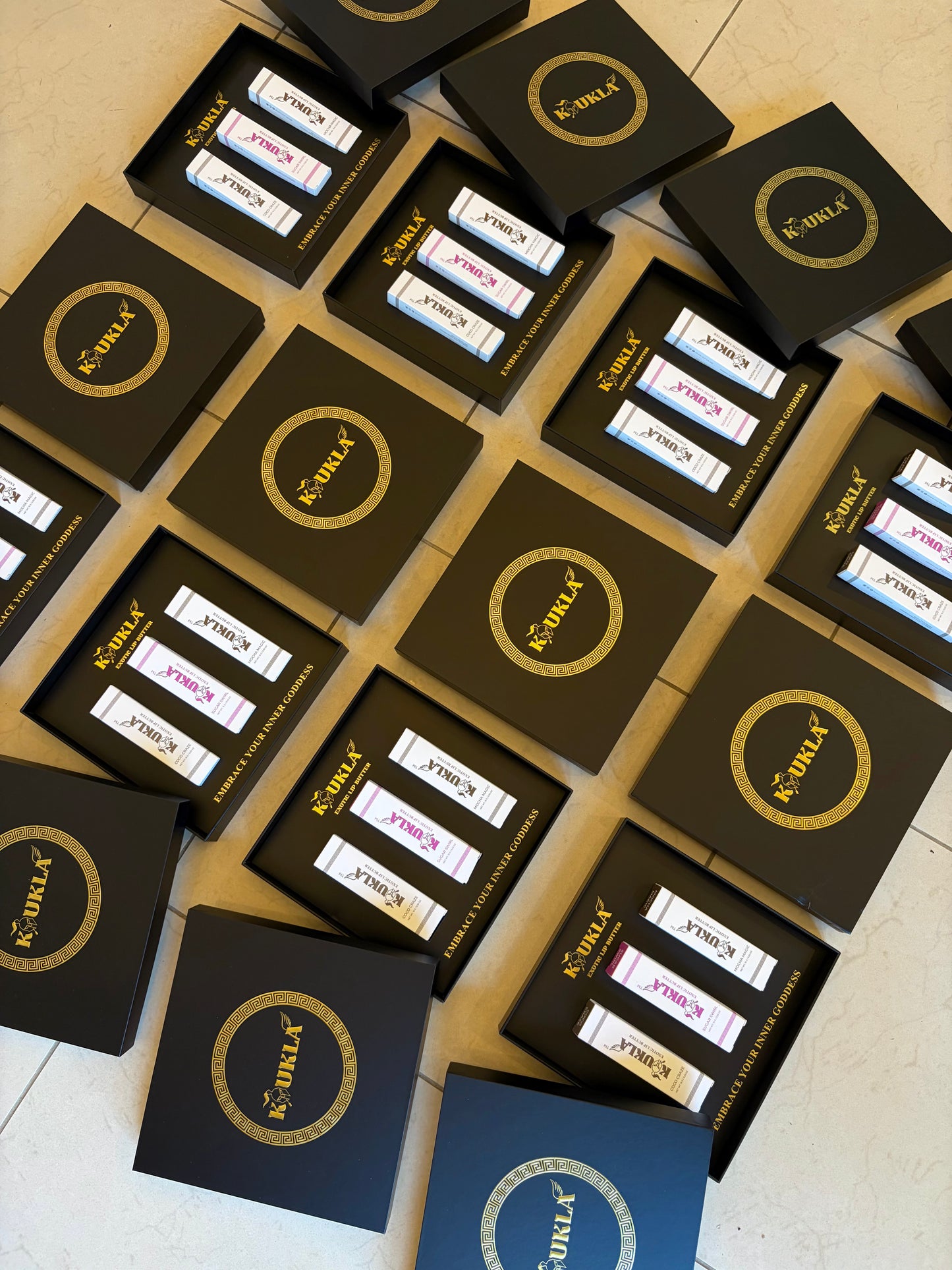 Multiple boxes with "Koukla" branding on a tiled floor.